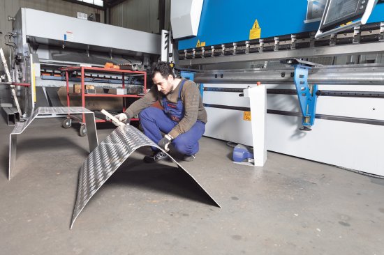 Componente mecanizado con radio para una cubierta de protección en el depósito de combustible de un transportador de madera