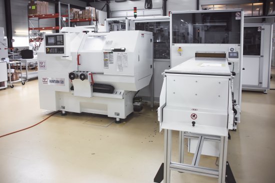 Zdjęcie powyżej: Skutecznie podłączona tokarka Numturn. Z przodu przenośnik taśmowy w obudowie do odtransportowania gotowych obrabianych elementów.